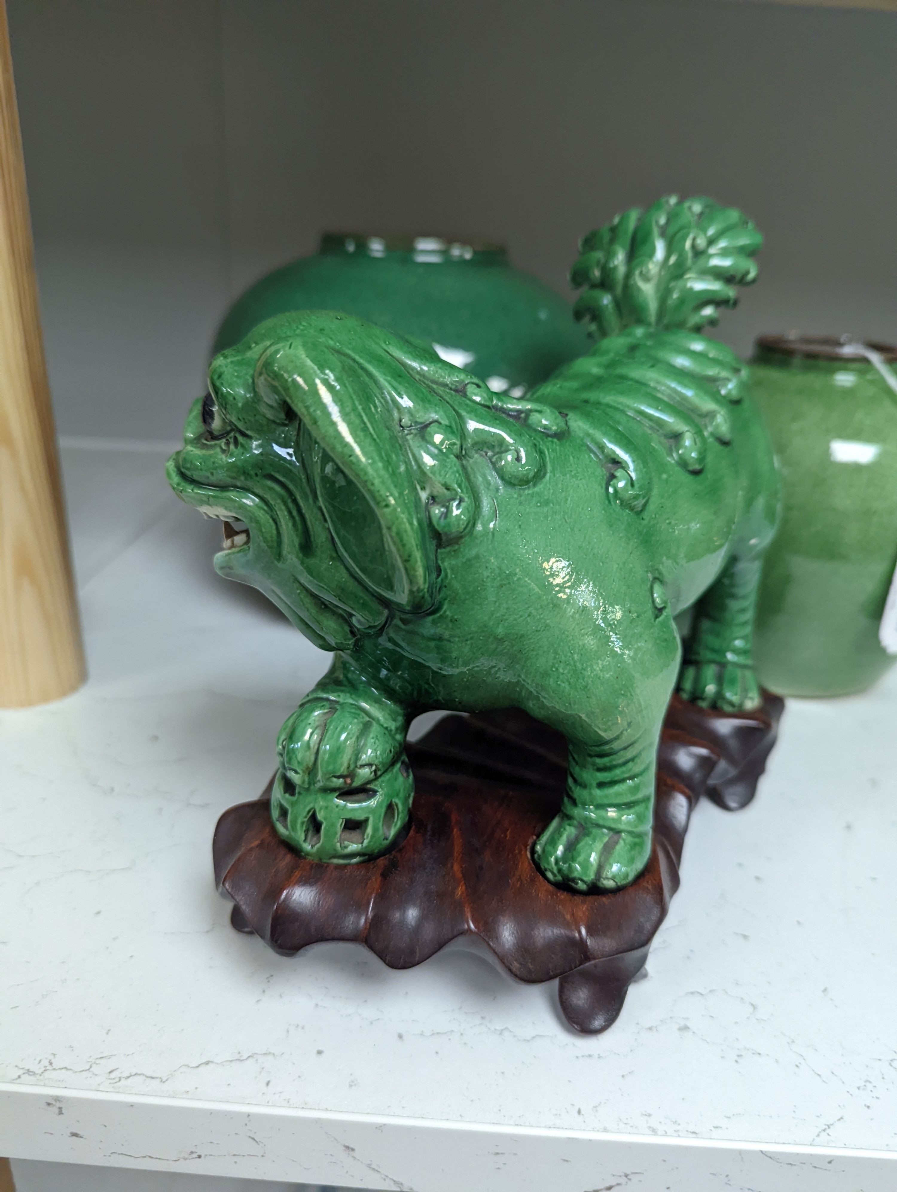 A 19th century Chinese green glazed model of a lion-dog, and two green crackle glaze jars, tallest 16cm